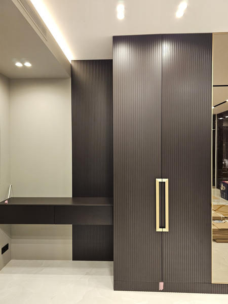 Встроенная корпусная Встроенная корпусная мебель с распашными фасадами из рифлёного МДФ в тёмном оттенке, интегрированная в интерьер с подвесной консолью, скрытым креплением и минималистичными латунными ручками, выполненная во всю стену с точной подгонкой по архитектуре помещения