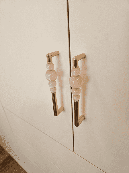 Деталь фурнитуры Деталь фурнитуры встроенного шкафа в детской комнате — дизайнерские ручки с декоративными элементами из прозрачных вставок. Ручки выполнены в светлом металлическом оттенке и подчёркивают аккуратный, эстетичный характер мебели. Использование качественной фурнитуры обеспечивает комфортную эксплуатацию и добавляет интерьеру индивидуальности и визуальной лёгкости.