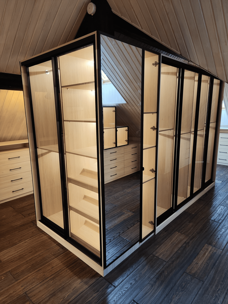 Гардеробная под Гардеробная под скатом крыши с остеклёнными шкафами и выдвижными ящиками