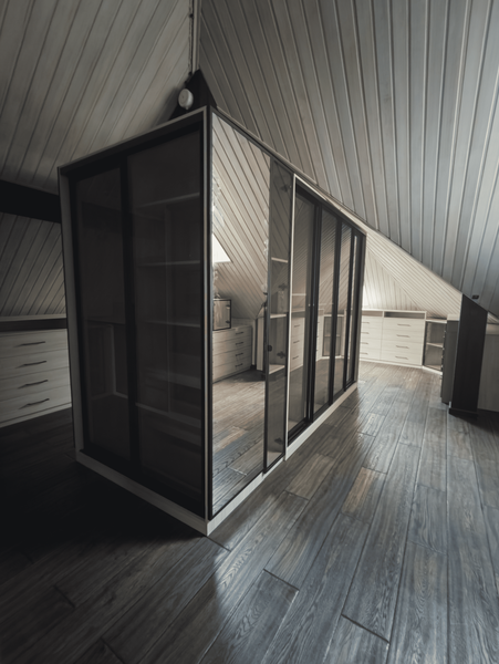 Мансардная гардеробная Мансардная гардеробная с островным модулем и стеклянными фасадами