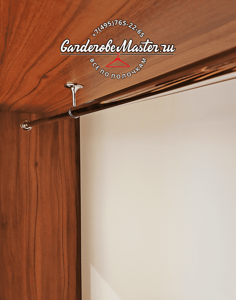 Деталь встроенной Деталь встроенной гардеробной системы с металлической хромированной штангой для одежды, закреплённой на потолочном держателе, предназначенной для надёжного хранения одежды в секциях с повышенной нагрузкой