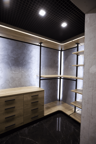 Открытая гардеробная система в современном стиле с деревянными полками, металлическими стойками и встроенной светодиодной подсветкой по вертикали, с угловой рабочей зоной и вместительным комодом для хранения