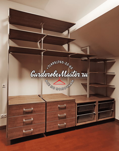 Гардеробная система с модульными деревянными секциями, выдвижными ящиками и сетчатыми корзинами, адаптированная под мансардное помещение с наклонным потолком