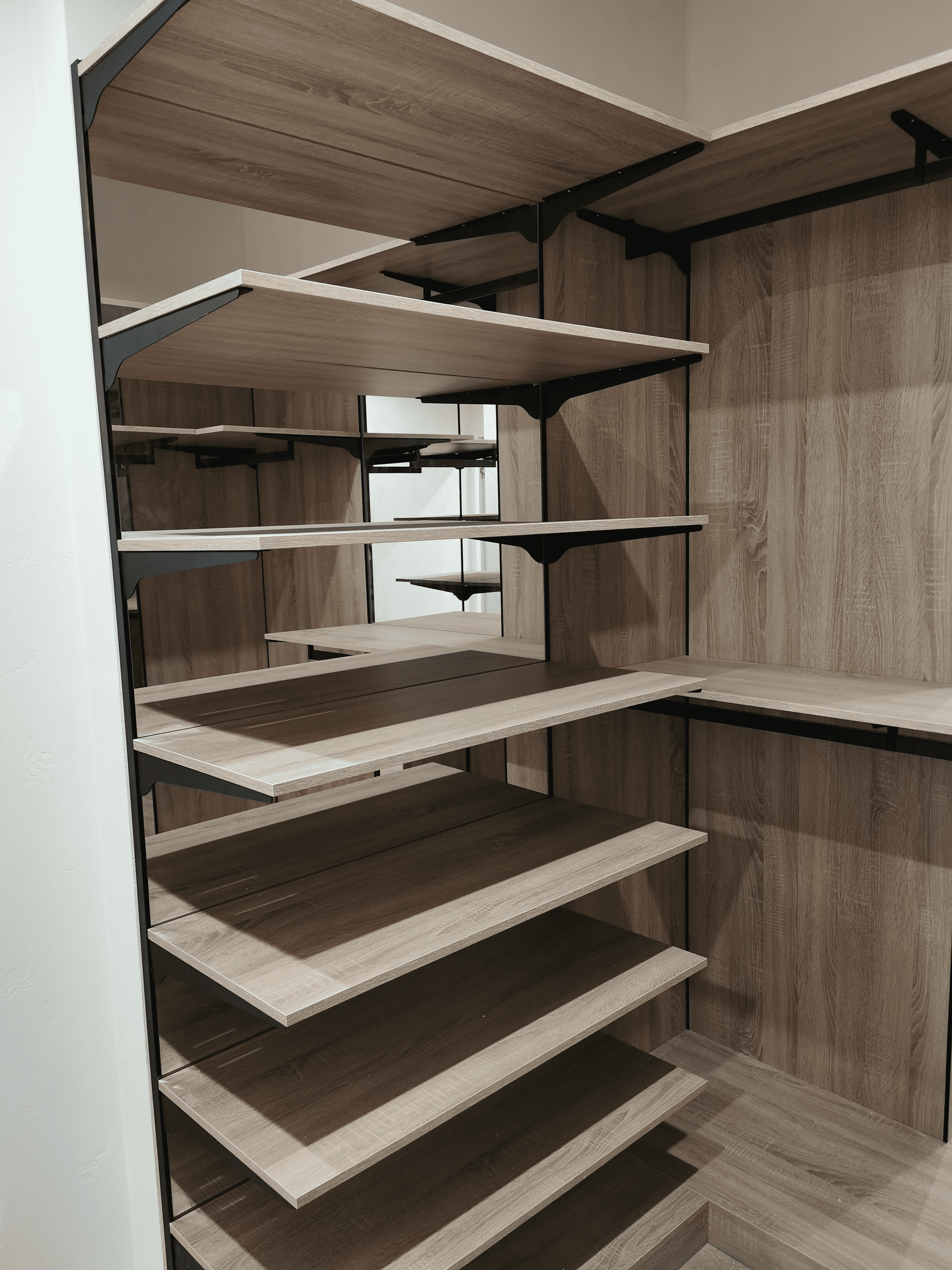 Открытая секция Открытая секция гардеробной с многоуровневыми деревянными полками на металлических кронштейнах