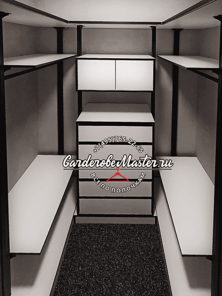 Готовая гардеробная Готовая гардеробная комната с центральным блоком ящиков и верхними шкафами, боковые секции с полками и штангами, нейтральная цветовая гамма и равномерное освещение