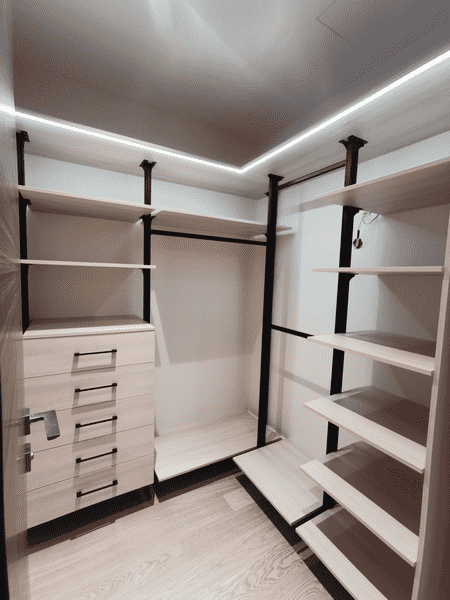 Светлая гардеробная Светлая гардеробная комната с подсветкой, металлическими стойками и открытыми полками