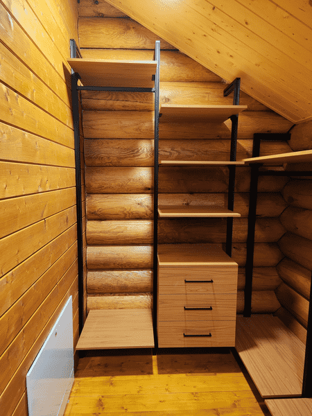 Гардеробная система Гардеробная система в мансардном помещении с деревянными стенами и комбинированными модулями хранения