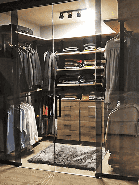 Гардеробная система Гардеробная система за стеклянными перегородками с ящиками и полками. Эстетичная гардеробная комната с удобной системой хранения.