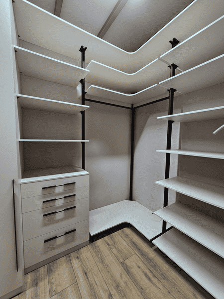 Гардеробная система Гардеробная система с интегрированной подсветкой и угловой компоновкой. Дизайн гардеробной комнаты с акцентом на удобство и порядок.