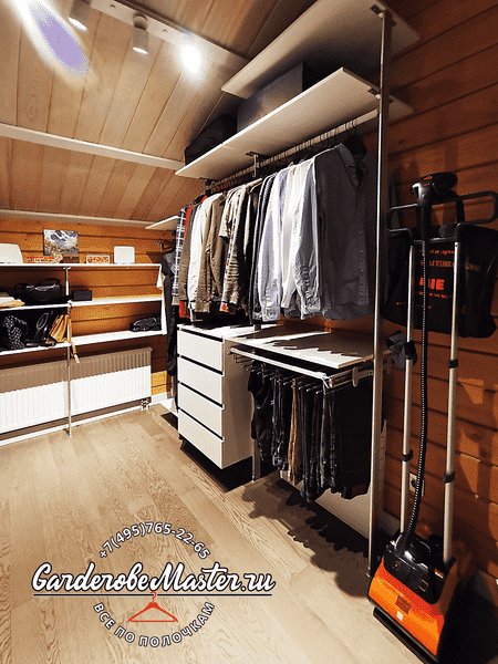 Мансардная гардеробная Мансардная гардеробная система с двухуровневыми штангами, выдвижными ящиками и встроенной подсветкой рабочих зон
