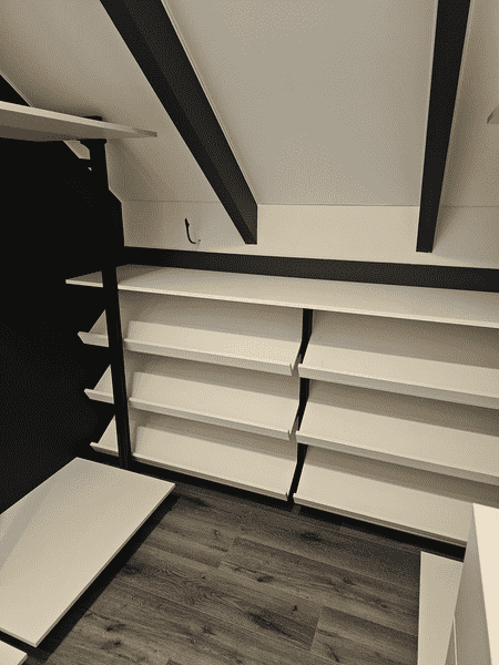 Гардеробная система Гардеробная система с пониженной высотой и вместительными полками. Рациональная планировка гардеробной комнаты под скатной крышей.