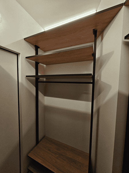 Металлическая гардеробная Металлическая гардеробная система с деревянными полками и встроенной подсветкой. Современный дизайн гардеробной комнаты с продуманной организацией хранения.